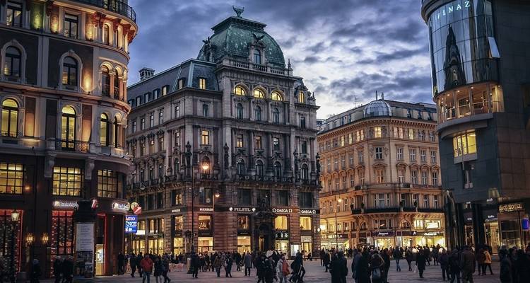 Vienna city square bustling with people at dusk.