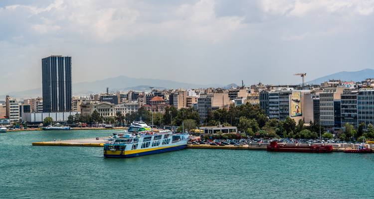Piraeus port with ferries and city skyline.