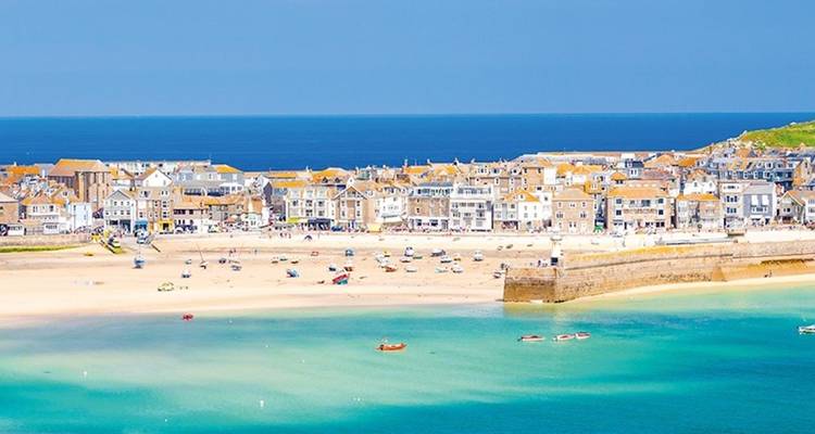 Kustplaats met zandstranden en kleurrijke gebouwen, waarschijnlijk in Engeland.