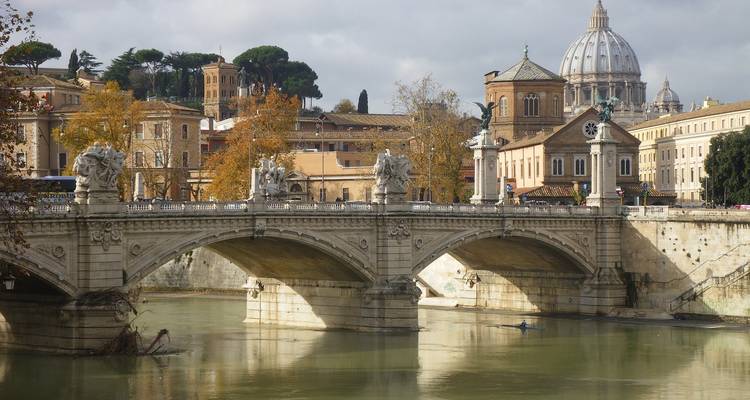 Bridge over the Tiber River with St. Peter's Basilica in the background.