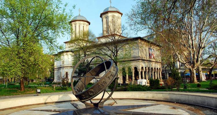 Sundial and church in a lush park.