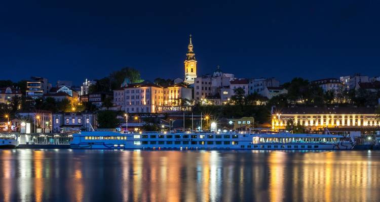 Skyline of Belgrade at night with illuminated architecture.