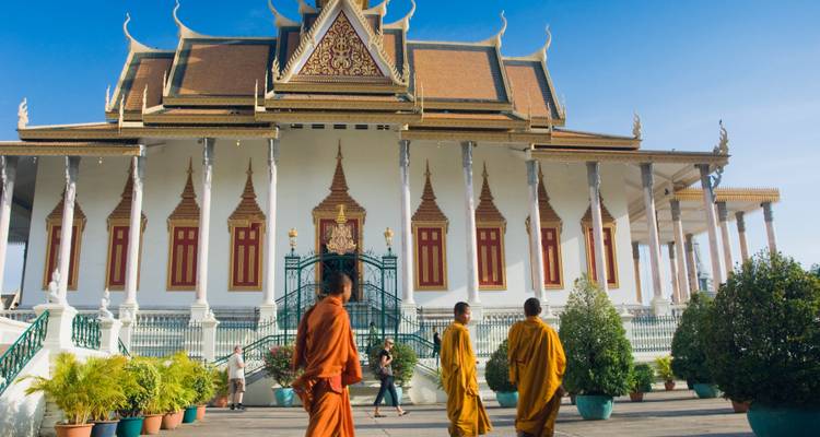 Monniken die voor een grote tempel lopen.