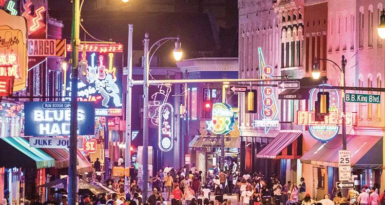 Les néons et les foules animées remplissent la scène nocturne vivante de Beale Street avec ses bars musicaux et sa signalétique.