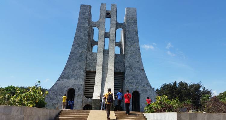 Besucher stehen auf den Stufen des modernen, mit Marmor verkleideten Kwame-Nkrumah-Mausoleums unter einem strahlend blauen Himmel.