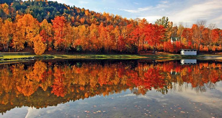 Autumn landscape with colorful foliage reflecting on a calm lake.