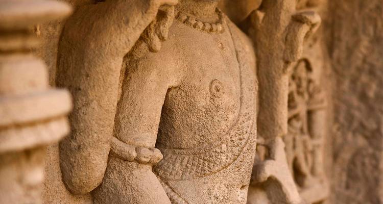 Close-up van een stenen sculptuur van een godheid.