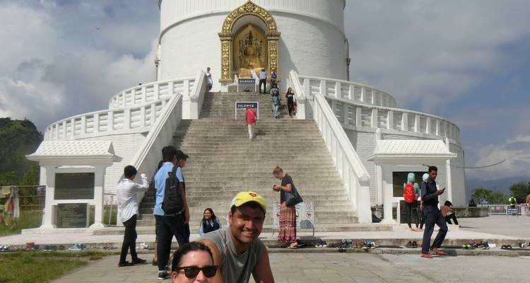 People in front of a large white pagoda.