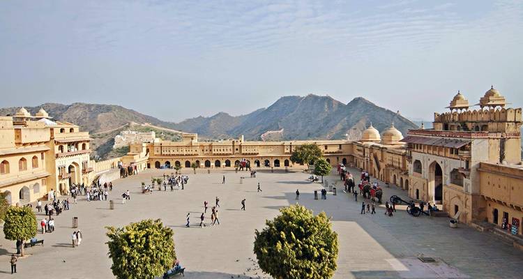 Plan large d'une cour ouverte dans un fort, des gens se promènent.