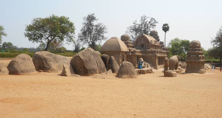 Rotsuitgehouwen tempels in een open landschap, heldere lucht erboven.