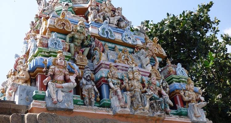 Eine farbenfrohe Tempelspitze mit skulptierten Gottheiten.