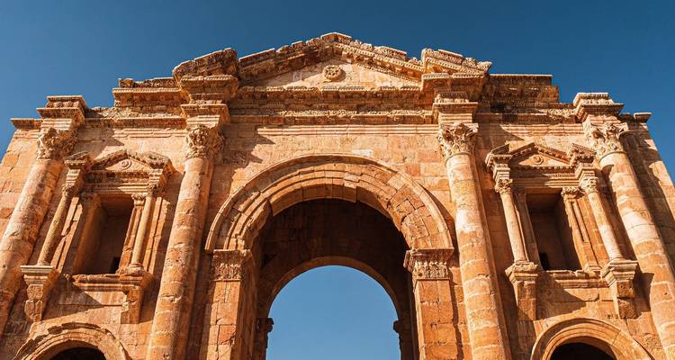 Beeindruckender römischer Bogen unter einem klaren blauen Himmel.