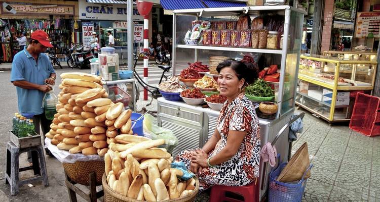 Street vendor with baguettes and other food.