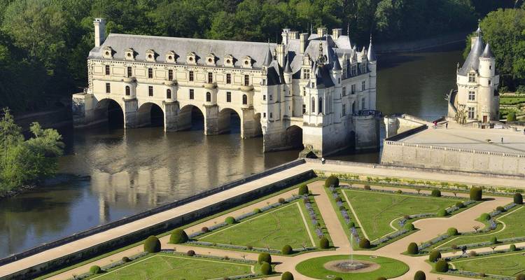 Château de conte de fées avec jardins et douves.