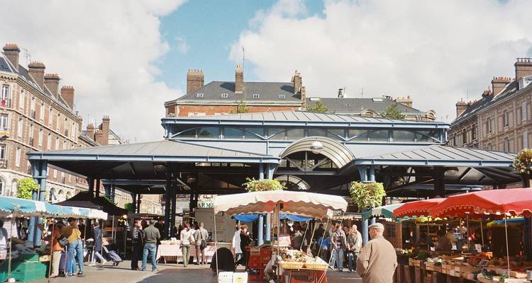 Marché extérieur animé avec des gens et des étals.