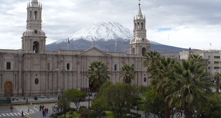 Cathédrale coloniale avec un volcan enneigé en arrière-plan.