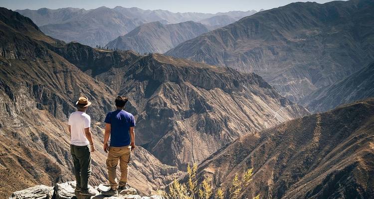 Deux hommes debout au bord d'un grand canyon.