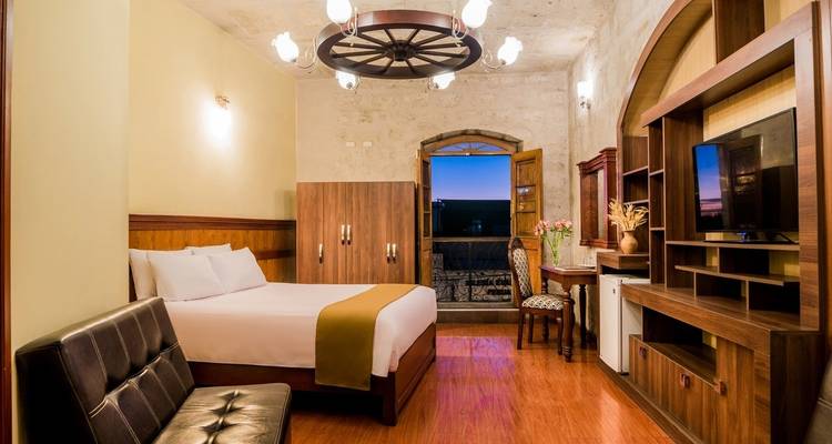 Chambre d'hôtel spacieuse avec un lit, un canapé et une télévision.