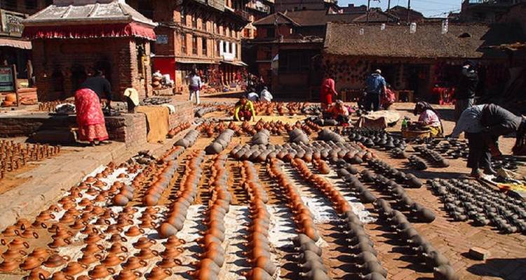 Scène de marché avec de la poterie exposée au sol.