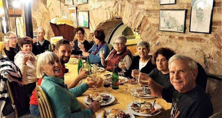 Groep mensen die samen dineren in een rustieke omgeving.