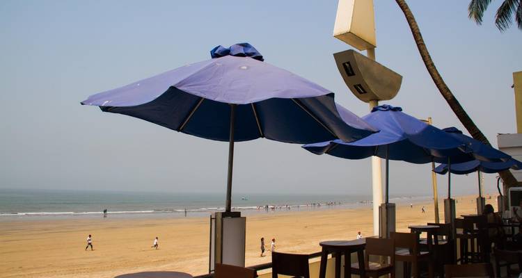 Strandgezicht met parasols en zithoek met uitzicht op zee.