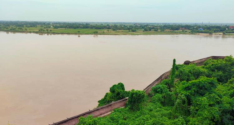 Wijd rivierzicht met groen en verre horizon.