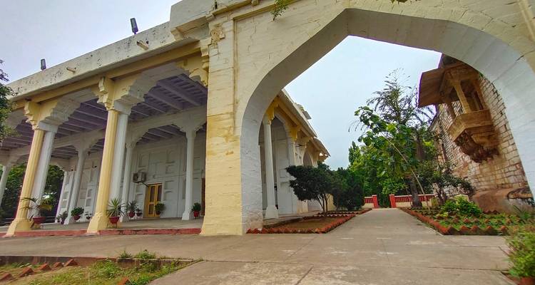 Traditioneel gebouw met een aarden pad en planten.