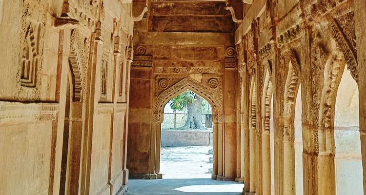 Oude gang met stenen bogen en ingewikkelde gravures.