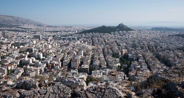Panoramic view of a city with a hill in the distance.