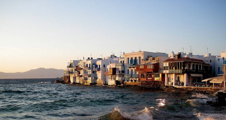 Seaside village with colorful buildings at sunset.