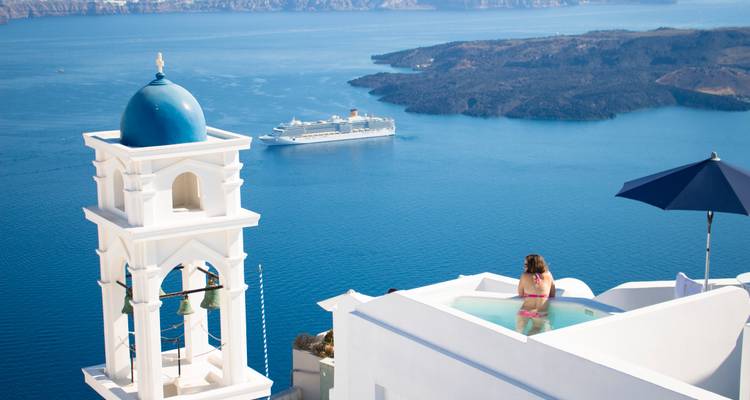 View of a chapel with a pool and cruise ship in the background.
