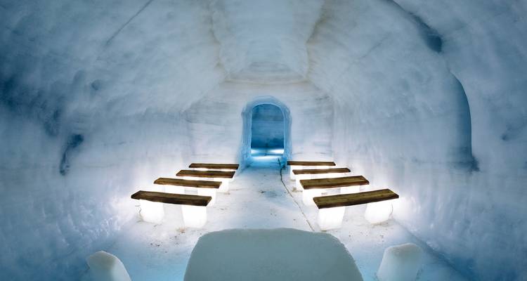 Interieur van een ijstunnel met banken van ijs.