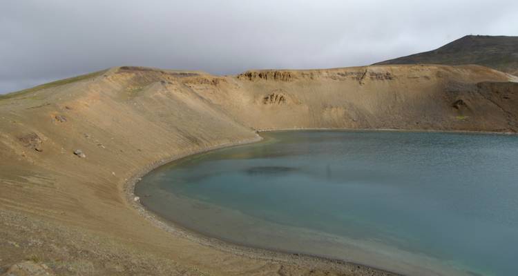 Vulkanisch kratermeer in een kaal landschap.
