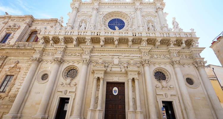 Gevel van een sierlijke kathedraal met gedetailleerde beeldhouwwerken.