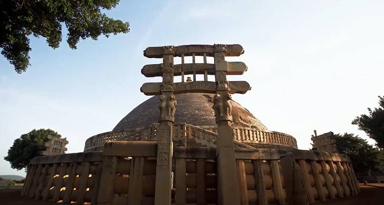 Zicht op een stupa met ingewikkelde gravures en heldere hemel.