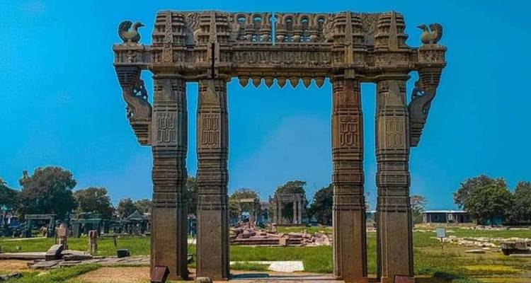 Ornate stone gate with intricate carvings and clear sky.