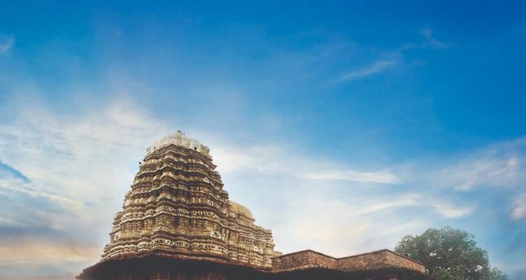 Tall ancient temple against a bright blue sky.