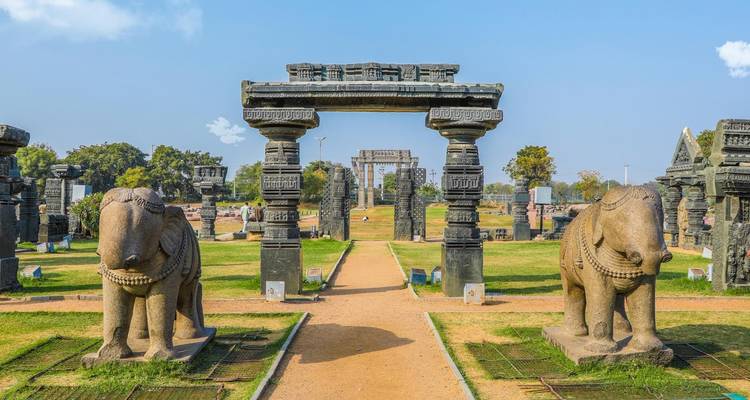 Ancient stone statues and a gate in a park.