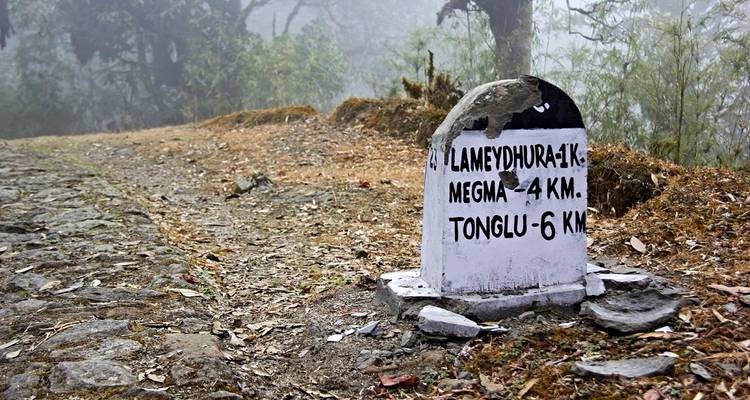 Straßenmeilenstein, der Entfernungen zu nahegelegenen Orten anzeigt.