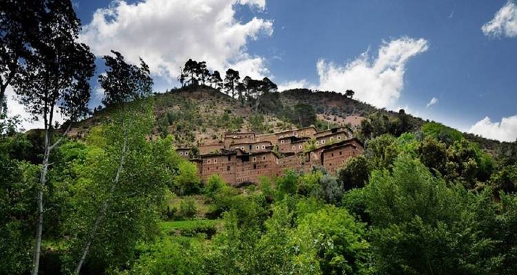 Village on a hill surrounded by lush greenery.