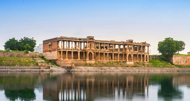 Een historisch gebouw aan een rivier, weerkaatsend op het water.
