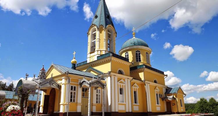 Kerk met blauwe koepels en een prominente klokkentoren.
