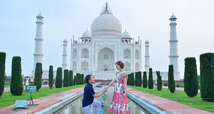 Un hombre se arrodilla para proponerle matrimonio a su pareja junto al estanque reflectante del Taj Mahal