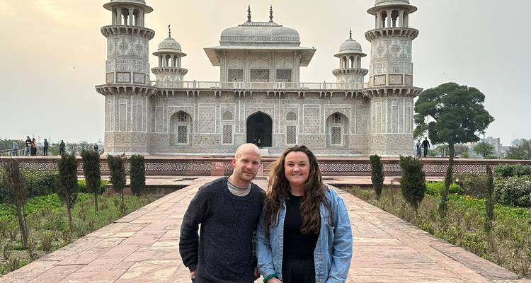 Pareja de pie frente al mausoleo de Itimad-ud-Daulah con incrustaciones de marfil al atardecer