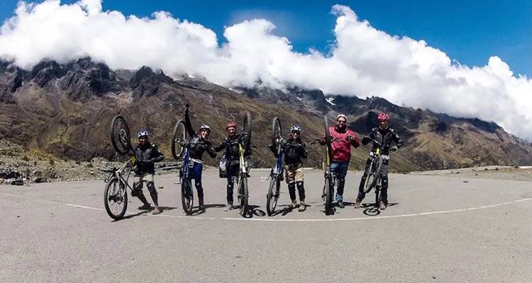 Grupo de ciclistas de montaña parados con sus bicicletas.