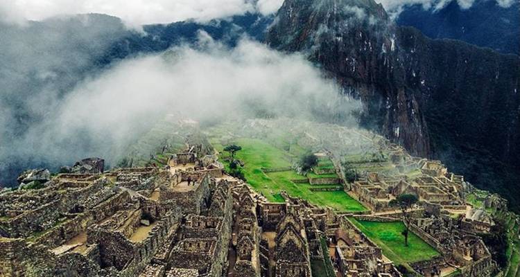 Machu Picchu visto desde la distancia con neblina.