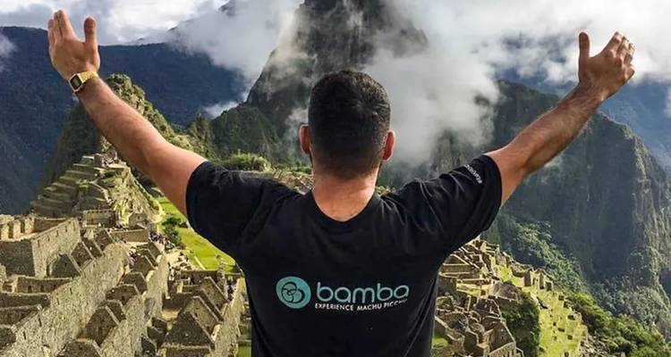 Personne avec les bras levés contemplant le Machu Picchu.