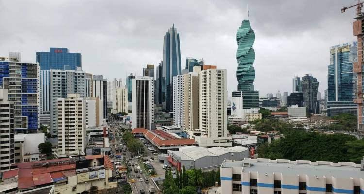 Horizonte de la moderna Ciudad de Panamá con la retorcida Torre F&F y la avenida bulliciosa abajo bajo nubes grises.