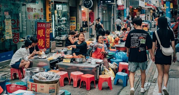 Scène de marché de rue animée avec des habitants qui font leurs courses et mangent.