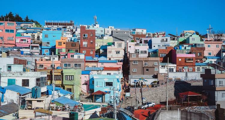 Maisons aux couleurs vives sur une colline sous un ciel bleu dégagé.